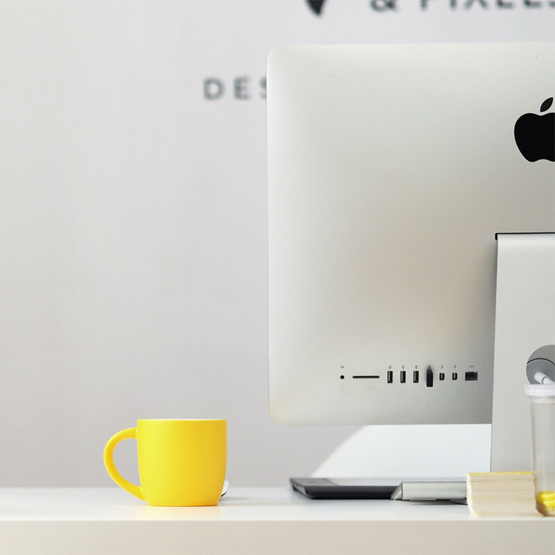 Tasse jaune et ordinateur moderne